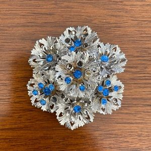 Vintage metal silver and blue rhinestone brooch.